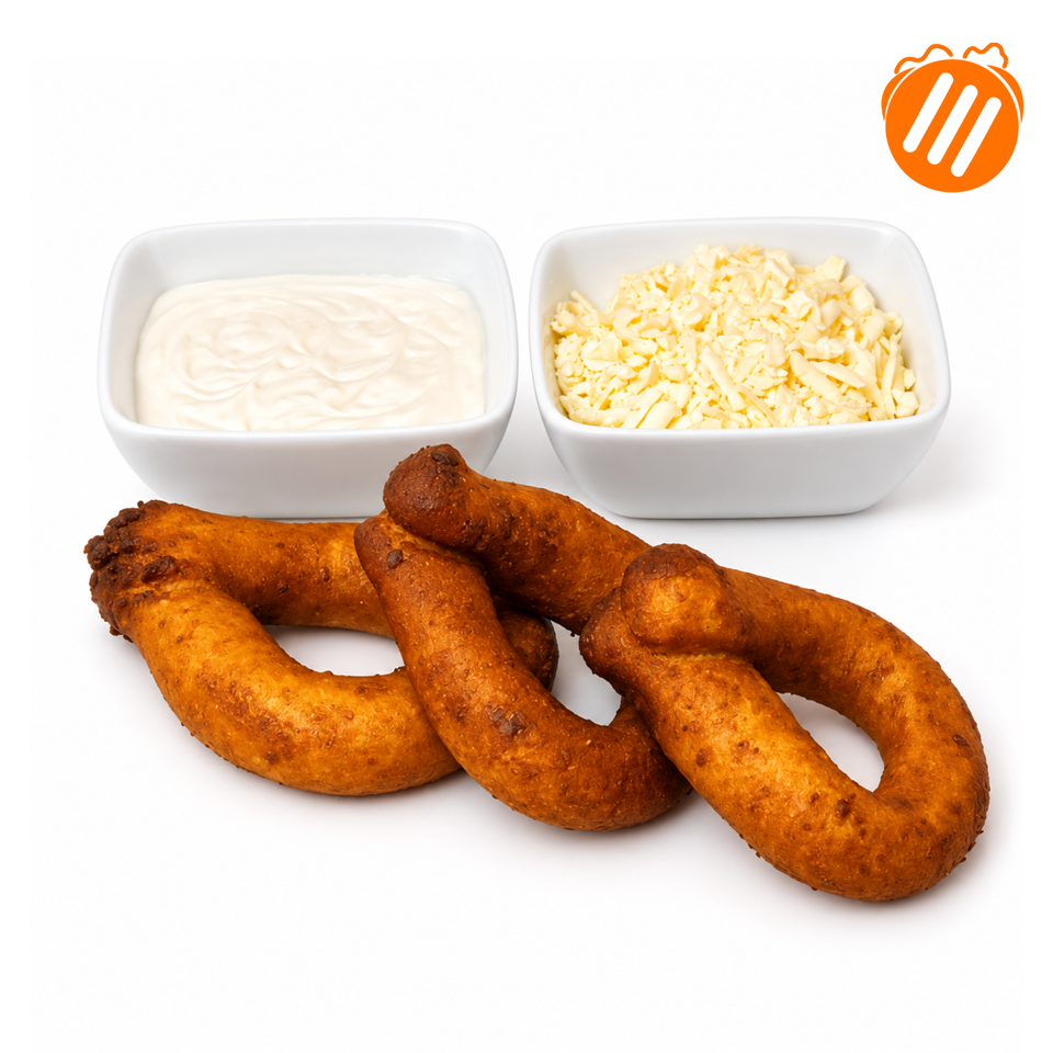 Golden-brown fried pretzel rings served with creamy dipping sauce and shredded cheese in white bowls.